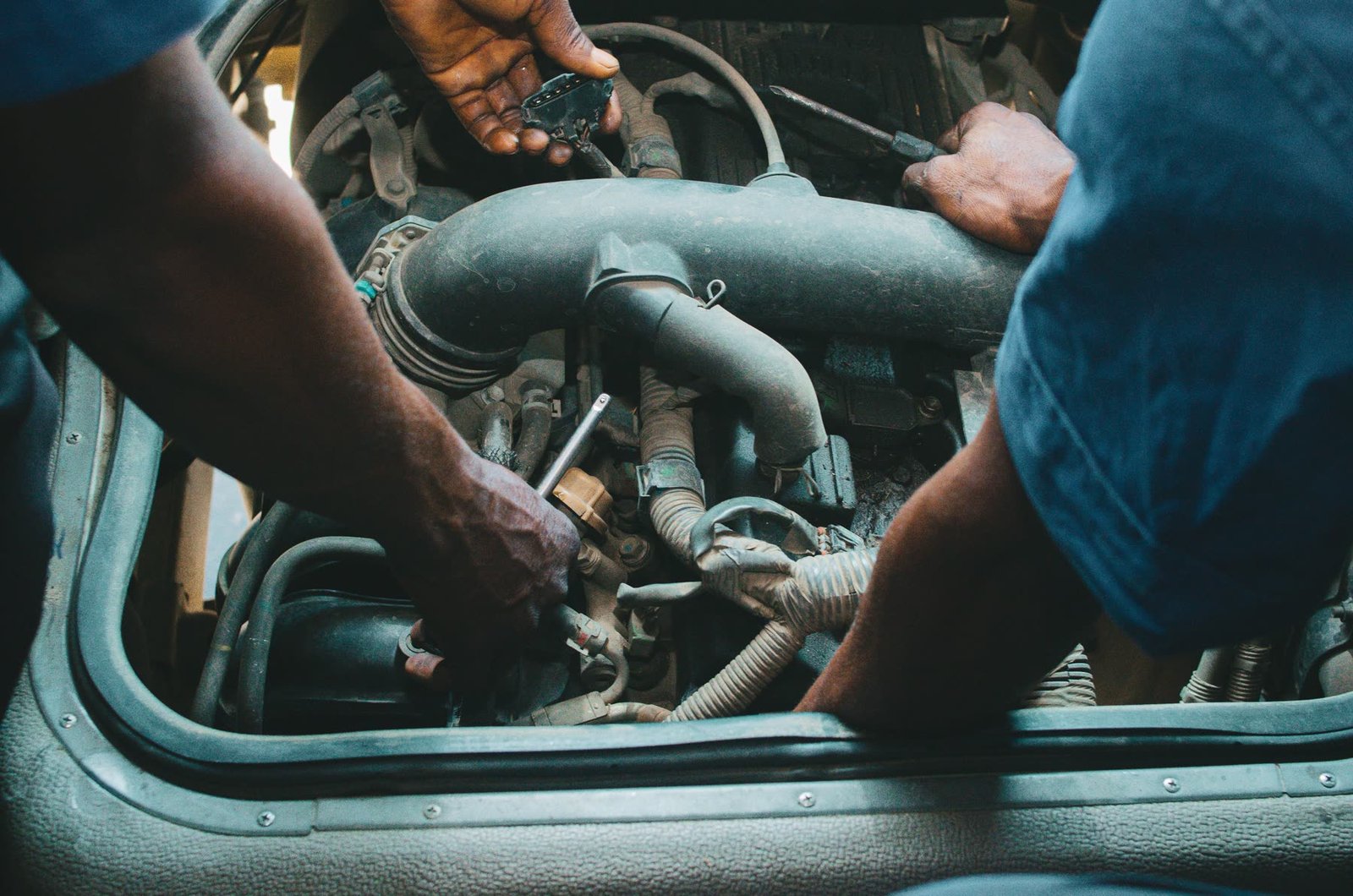 Two mechanics working together in an engine bay