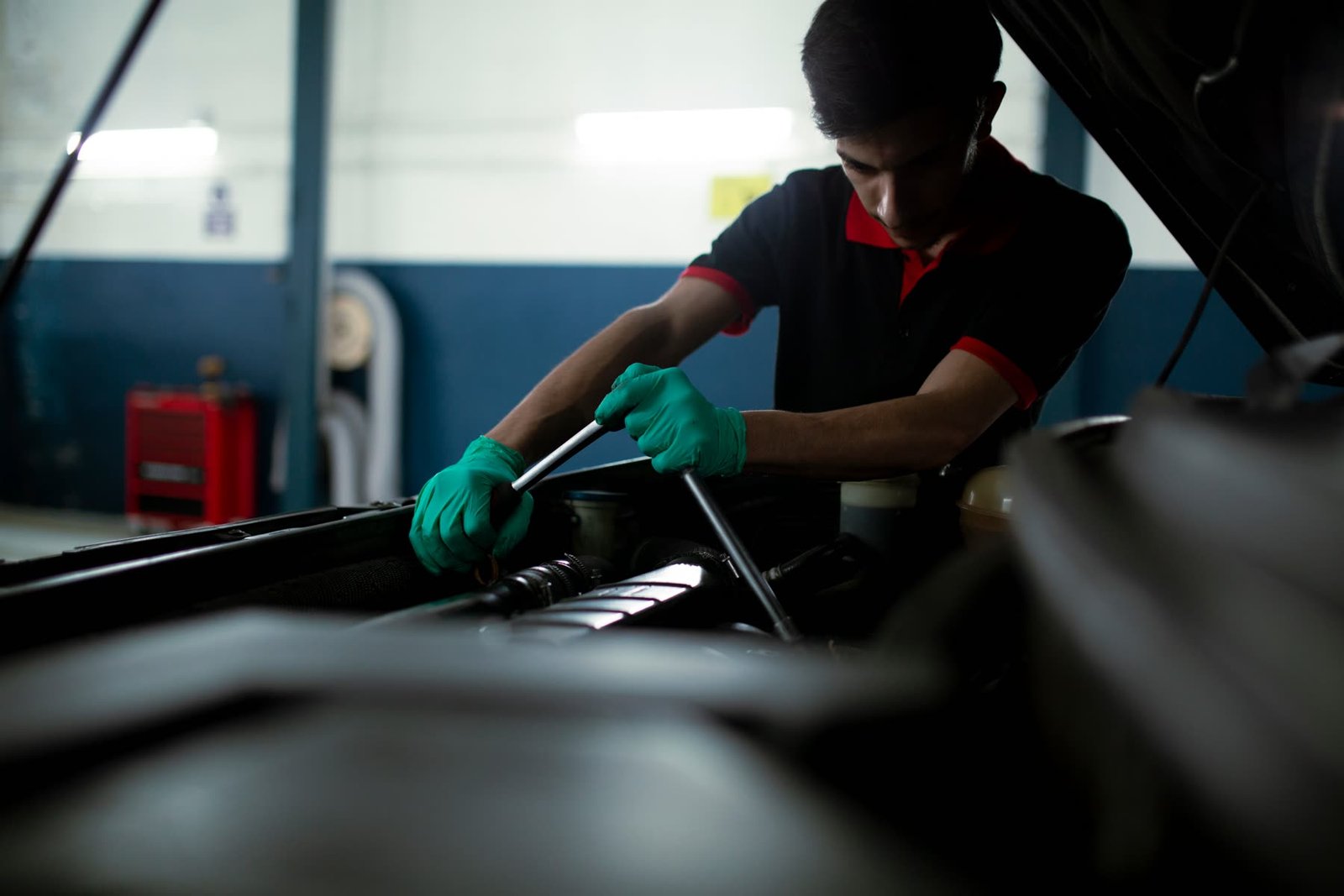 Mechanic working under the bonnet with a ratchet