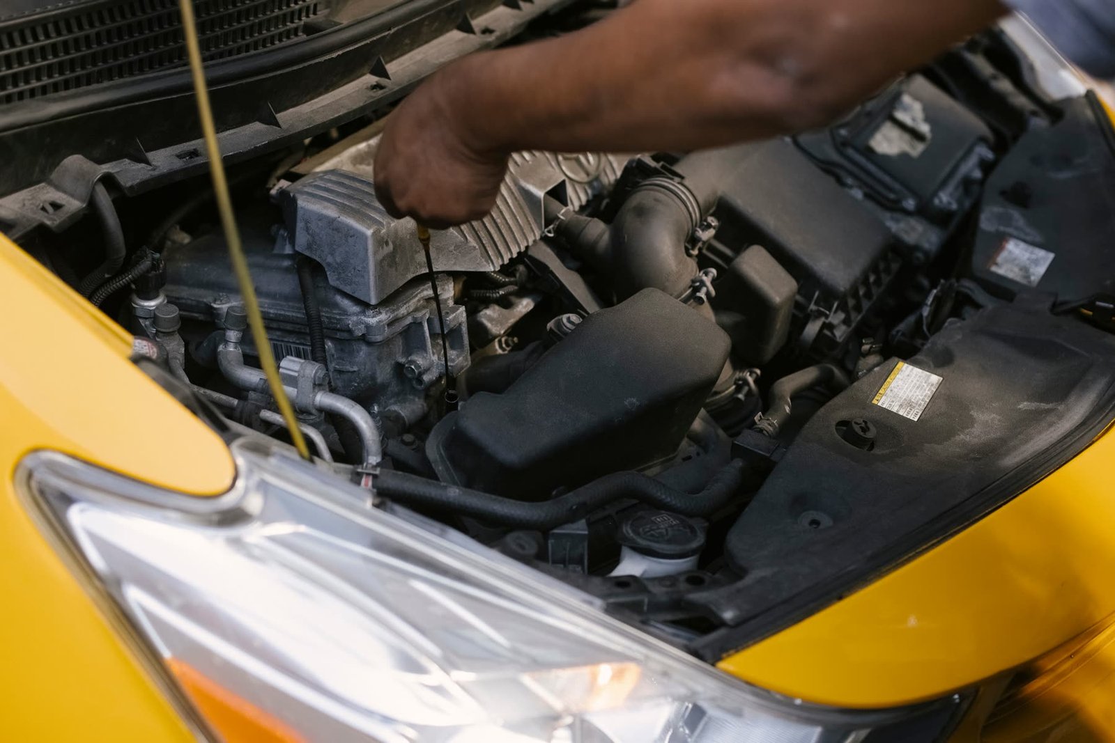 Mechanic checking engine oil during a logbook service