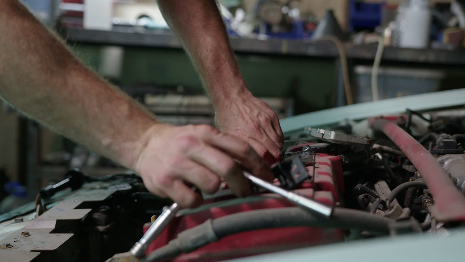 Mechanic using tools under the bonnet of a car